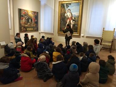 bambini ascoltano la guida al museo